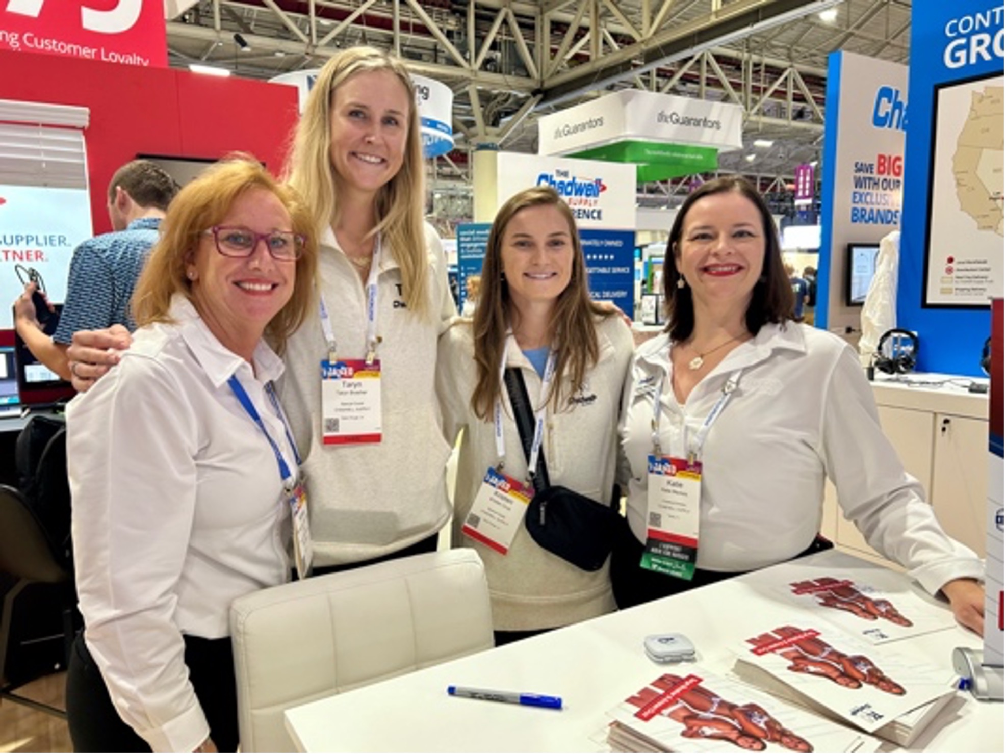 Taryn Brasher and Kristen Cruz visiting the Chadwell Supply booth with team members